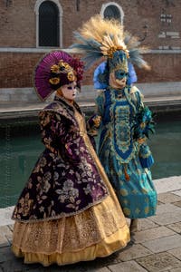 People in costume at the Venice Carnival in front of the Venetian Arsenal.