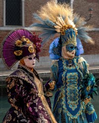 People in costume at the Venice Carnival in front of the Venetian Arsenal.