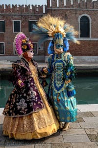 People in costume at the Venice Carnival in front of the Venetian Arsenal.