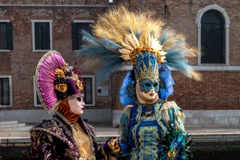 People in costume at the Venice Carnival in front of the Venetian Arsenal.