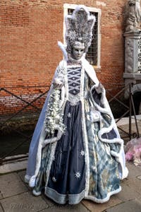 People in costume at the Venice Carnival in front of the Venetian Arsenal.