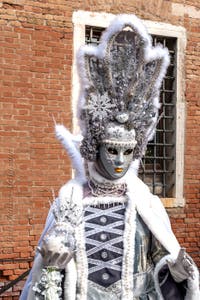 People in costume at the Venice Carnival in front of the Venetian Arsenal.