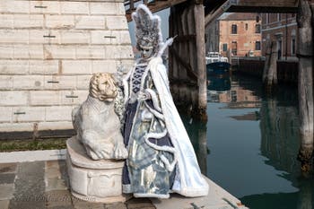 People in costume at the Venice Carnival in front of the Venetian Arsenal.