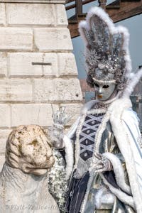 People in costume at the Venice Carnival in front of the Venetian Arsenal.