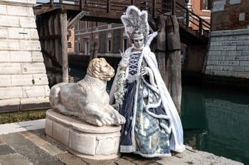 People in costume at the Venice Carnival in front of the Venetian Arsenal.