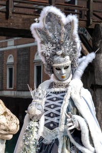 People in costume at the Venice Carnival in front of the Venetian Arsenal.