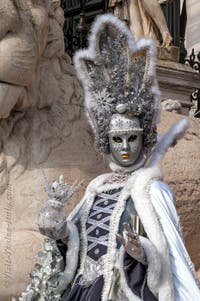 People in costume at the Venice Carnival in front of the Venetian Arsenal.