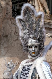 People in costume at the Venice Carnival in front of the Venetian Arsenal.