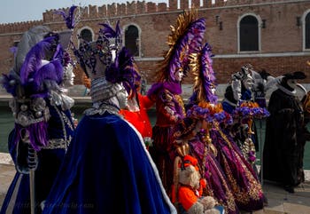 People in costume at the Venice Carnival in front of the Venetian Arsenal.