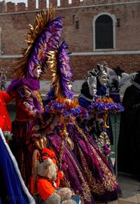 People in costume at the Venice Carnival in front of the Venetian Arsenal.