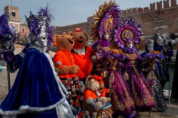 People in costume at the Venice Carnival in front of the Venetian Arsenal.