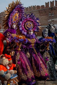 People in costume at the Venice Carnival in front of the Venetian Arsenal.