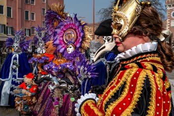 People in costume at the Venice Carnival in front of the Venetian Arsenal.