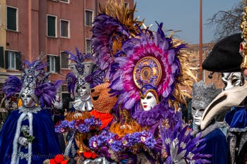 People in costume at the Venice Carnival in front of the Venetian Arsenal.