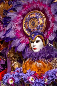 People in costume at the Venice Carnival in front of the Venetian Arsenal.