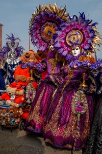 People in costume at the Venice Carnival in front of the Venetian Arsenal.