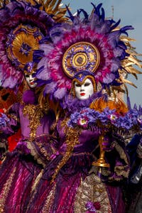 People in costume at the Venice Carnival in front of the Venetian Arsenal.