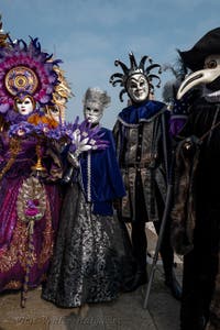 People in costume at the Venice Carnival in front of the Venetian Arsenal.