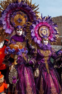 People in costume at the Venice Carnival in front of the Venetian Arsenal.