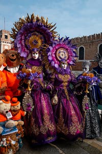 People in costume at the Venice Carnival in front of the Venetian Arsenal.