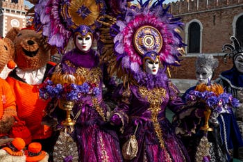 People in costume at the Venice Carnival in front of the Venetian Arsenal.