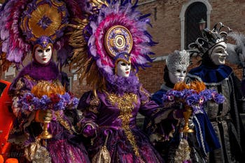 People in costume at the Venice Carnival in front of the Venetian Arsenal.