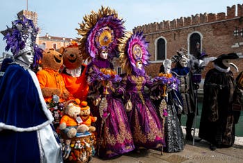 People in costume at the Venice Carnival in front of the Venetian Arsenal.