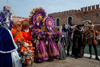 People in costume at the Venice Carnival in front of the Venetian Arsenal.