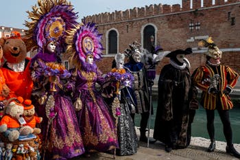 People in costume at the Venice Carnival in front of the Venetian Arsenal.