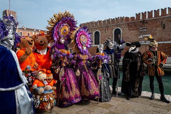 People in costume at the Venice Carnival in front of the Venetian Arsenal.