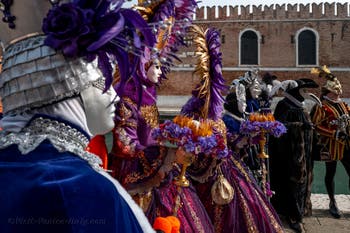 People in costume at the Venice Carnival in front of the Venetian Arsenal.