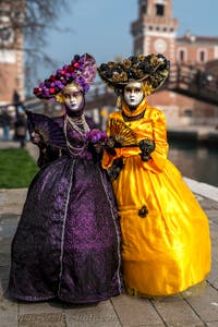 People in costume at the Venice Carnival in front of the Venetian Arsenal.