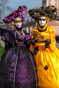 People in costume at the Venice Carnival in front of the Venetian Arsenal.