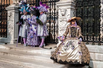 People in costume at the Venice Carnival in front of the Venetian Arsenal.