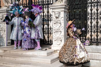 People in costume at the Venice Carnival in front of the Venetian Arsenal.