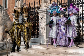 People in costume at the Venice Carnival in front of the Venetian Arsenal.