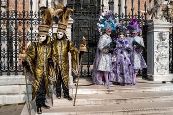 People in costume at the Venice Carnival in front of the Venetian Arsenal.