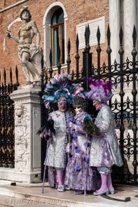 People in costume at the Venice Carnival in front of the Venetian Arsenal.