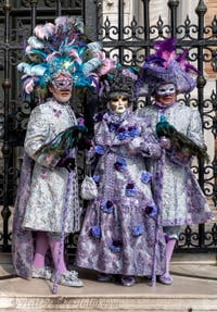 People in costume at the Venice Carnival in front of the Venetian Arsenal.