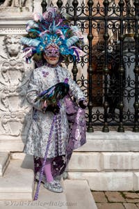 People in costume at the Venice Carnival in front of the Venetian Arsenal.