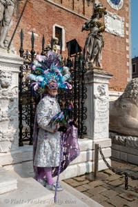 People in costume at the Venice Carnival in front of the Venetian Arsenal.