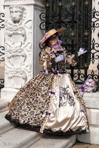 People in costume at the Venice Carnival in front of the Venetian Arsenal.