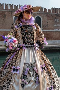 People in costume at the Venice Carnival in front of the Venetian Arsenal.