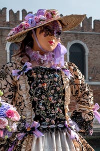 People in costume at the Venice Carnival in front of the Venetian Arsenal.