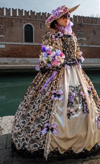 People in costume at the Venice Carnival in front of the Venetian Arsenal.