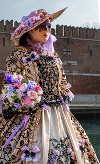 People in costume at the Venice Carnival in front of the Venetian Arsenal.