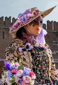 People in costume at the Venice Carnival in front of the Venetian Arsenal.