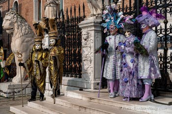 People in costume at the Venice Carnival in front of the Venetian Arsenal.