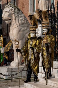 People in costume at the Venice Carnival in front of the Venetian Arsenal.