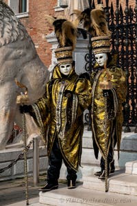 People in costume at the Venice Carnival in front of the Venetian Arsenal.